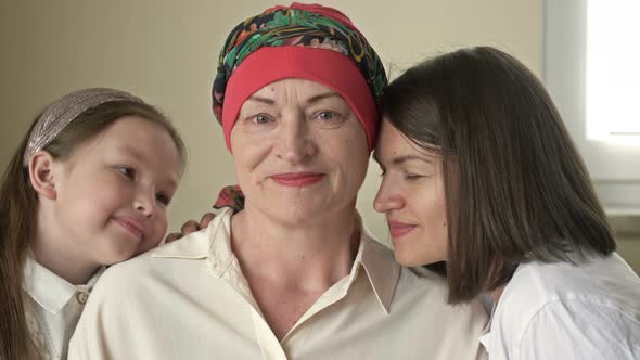 An Adult Daughter and Little Granddaughter Hug a Sad Elderly Woman Who Has Gone Bald After alt