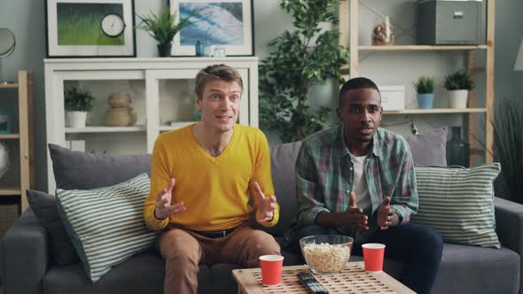 Joyful Male Students Are Watching Sports Game on TV Supporting Favourite Team Then Celebrating alt