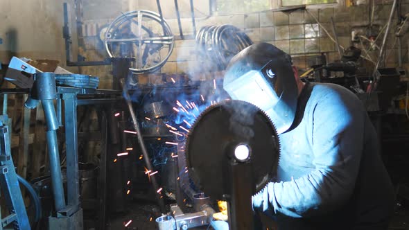 Worker in Protective Mask Welding Metal Construction at Industrial Production alt