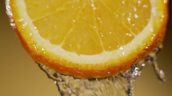 Water Splashing on Fresh Orange in Slow Motion alt
