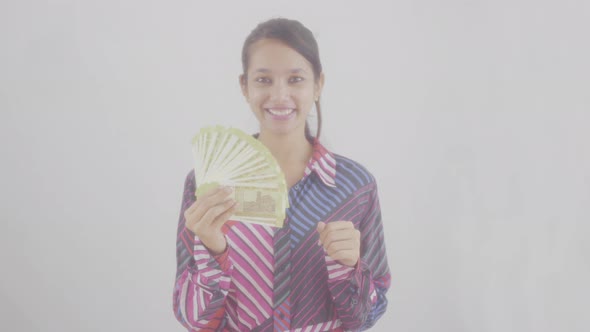 Young girl enjoying holding Indian rupee notes in her hand