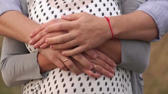 Closeup Husband Gently Stroking His Pregnant Wife's Tummy Outdoors alt