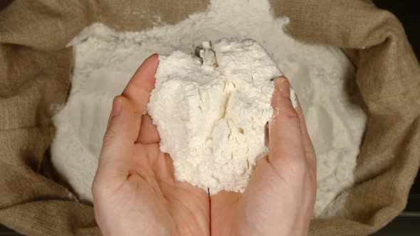Human takes of a wheat powder by a hands from a sac