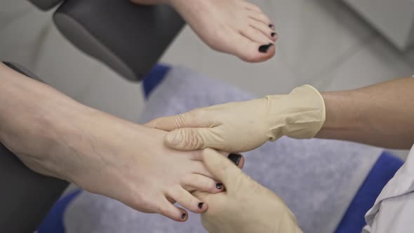 Podiatrist Makes Massage of the Fingers the Feet of the Patient with His Hands