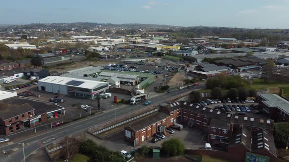 Aerial drone panning across rural village houses and supermarket, Essex England alt