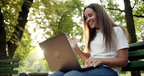 Woman Having Videochat on Laptop in Park