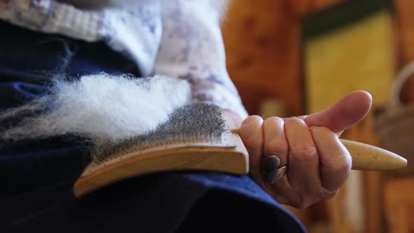 Senior citizen brushing woollen pulp with brush alt