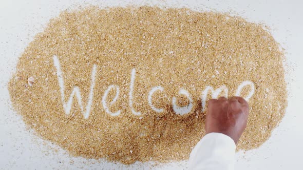 Hand Writes On Beach Sand Welcome alt