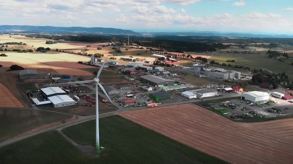 Rotating wind turbine against industrial plants and factories alt