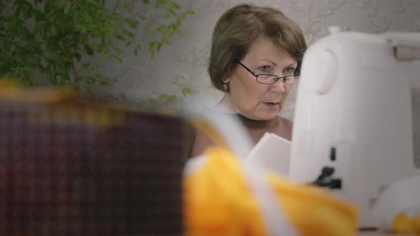 Senior Woman Use Sewing Machine At Home