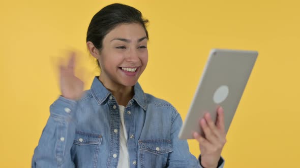 Video Chat on Tablet By Indian Woman, Yellow Background  alt