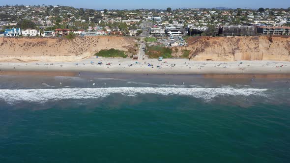 Drone shot flying towards Solana Beach and coastal city in San Diego, America alt