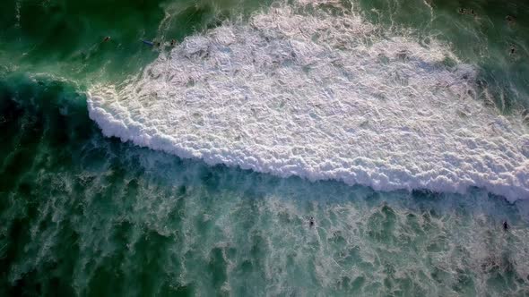 Surfer ducks under a crashing wave in Dreamland beach Bali Indonesia, Top view rotating shot alt