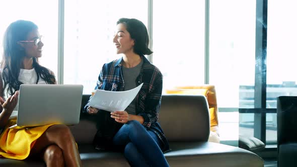 Female executives discussing over laptop 4k alt