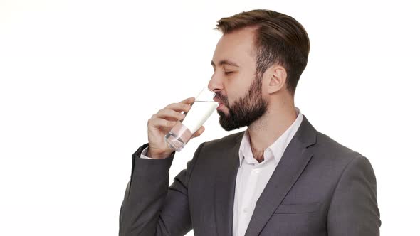 Horizontal Portrait of Pleased Glad Guy Wearing Office Suit Drinking Mineral Water From Transparent alt