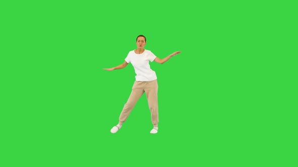 Young Girl in White Tshirt Enjoys Dancing on a Green Screen Chroma Key