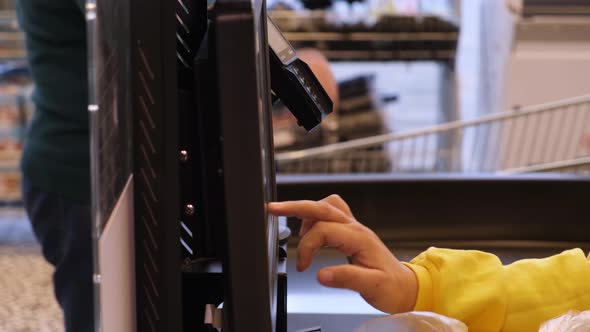 the Hand of the Saleswoman at the Checkout in the Supermarket Punches the Bill alt