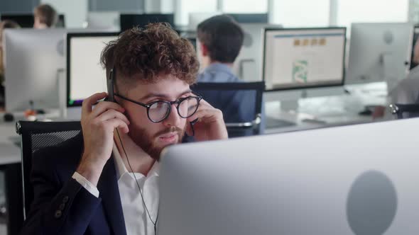 Portrait of a Technical Customer Support Specialist Talking on a Headset While Working on a Computer alt