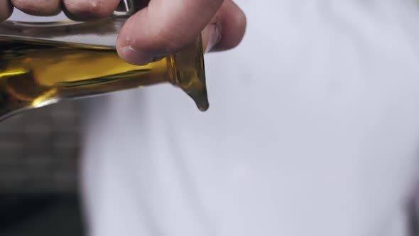 Close Up of the Oil Pouring on the Food Chef in the Restaurant alt
