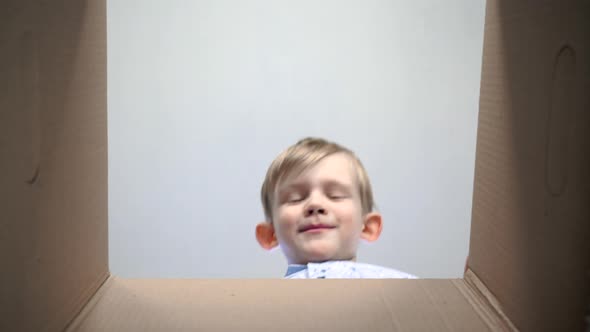 Schoolboy Opens a Box with a Gift, Happy Surprised Emotions