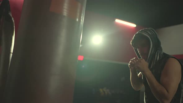 Caucasian attractive sport man workout, exercising doing boxing hitting a punching bag at fitness. alt