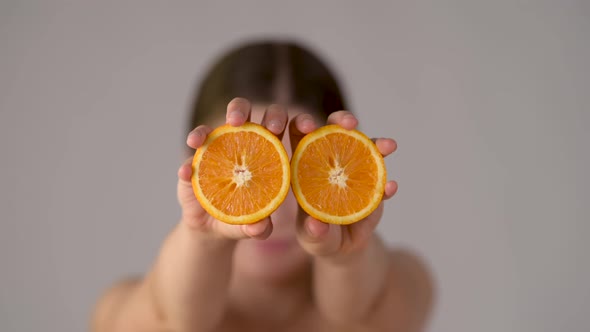 Young healthy girl with slices of orange citrus fruit