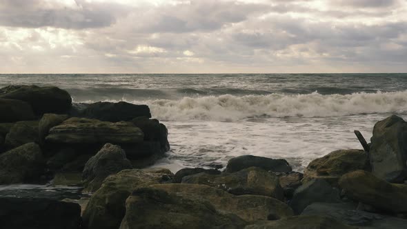 Foam Waves Roll on Rocks After a Storm