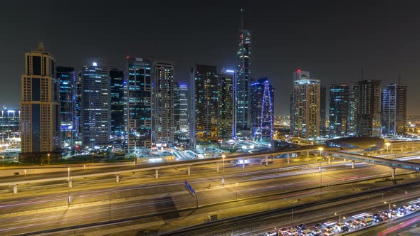 Aerial View of Jumeirah Lakes Towers Skyscrapers Night Timelapse with Traffic on Sheikh Zayed Road alt