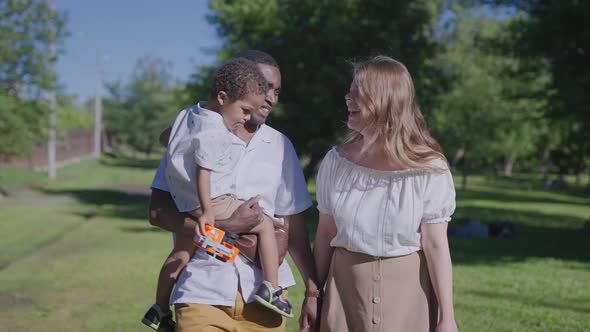 A Multinational Family is Walking in the Park alt