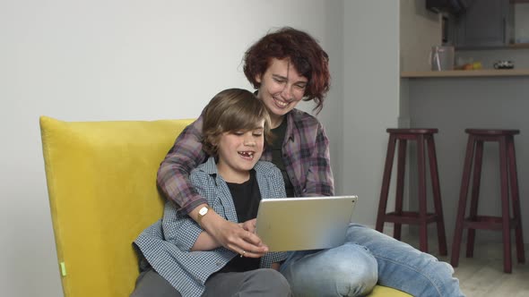 Happy Mother and Child Using Digital Tablet at Home