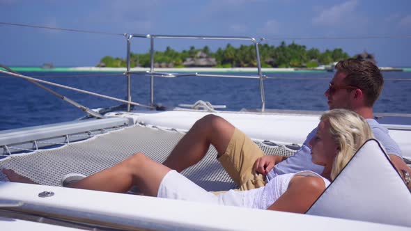 A couple relaxing on a boat at a tropical island resort hotel alt