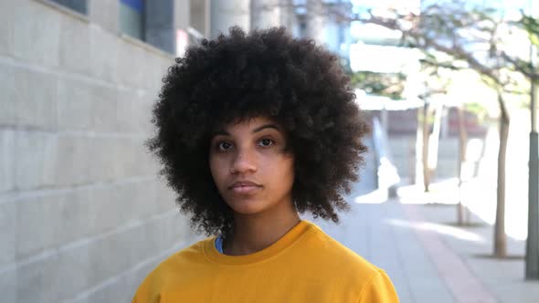 portrait of one young beautiful African or American woman looking at the camera with seriously alt