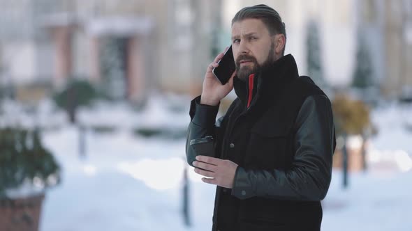 Man Having Mobile Talk on Snowy Street alt