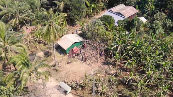 Aerial clip of unfinished house under construction in Battambang Cambodia during a hot dusty summer alt