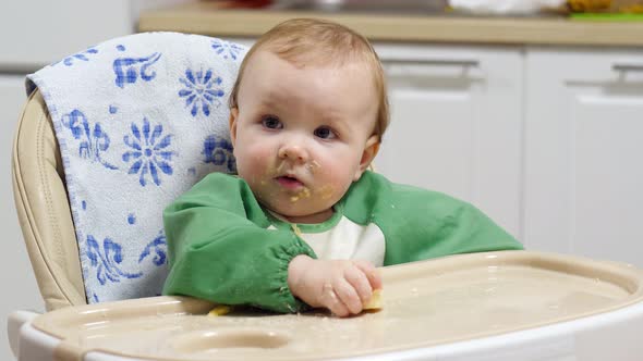 Little girl is trying to eat a banana, covered in bits of food, portrait shot alt
