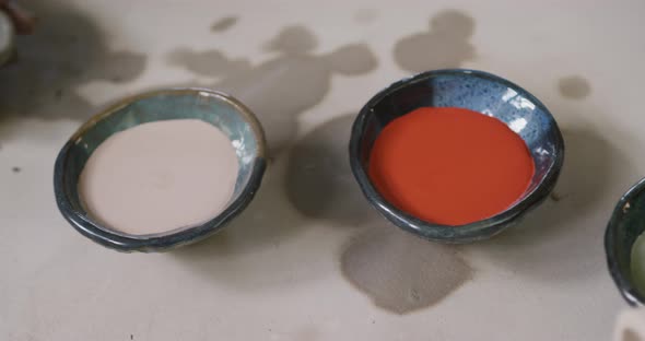 Close up view of female potter working on clay to create pot at pottery studio alt