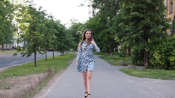 Gorgeous Woman in Dress Walking Towards Camera in the Street