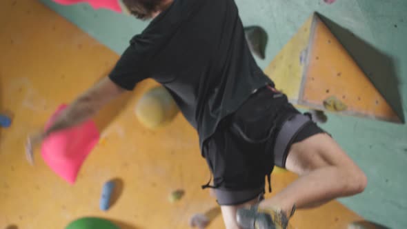 Young Man Climbs Up An Artificial Rock WallSport And Fitness Concept Side View