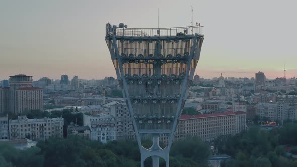 Light Tower of a Football Stadium Against a Sunset and a Night City