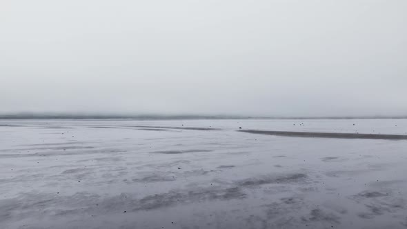 Drone Flight Over Black Sand Beach From Misty Sea alt