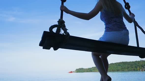 Girl Sits on a Swing By the Sea. Thailand. Koh Kood