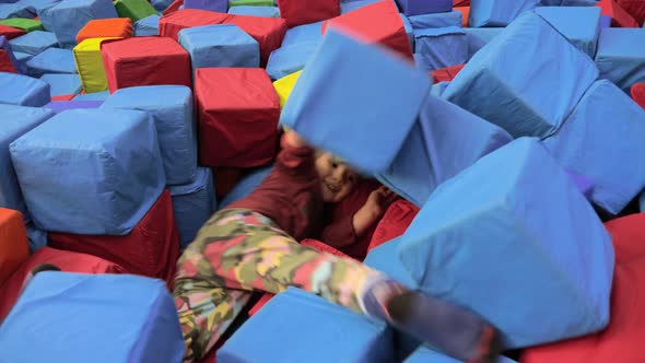Boy dives into the pool filled with soft blocks. Indoor games. Leisure activity. Exciting games alt