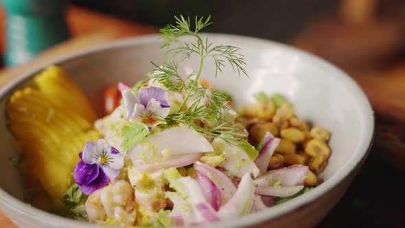 Cinematic slow motion close up shot of a chef completing the peruvian appetizer ceviche dish by garn alt