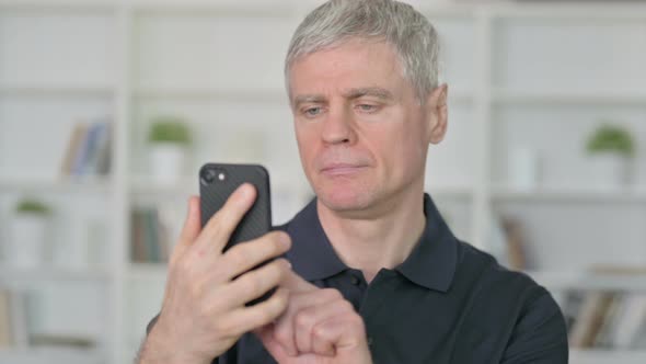 Relaxed Middle Aged Businessman Using Smartphone  alt