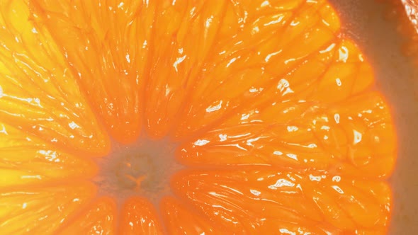 Drop of Water Flows Down the Surface of a Ripe Juicy Orange Slice alt
