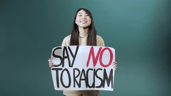 A Handsome Asian Lady is Standing Smiling and Calling on Everyone to Fight Racism alt