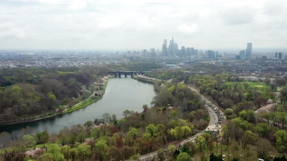 Aerial drone pan left of Philadelphia city skyline from above the Schuylkill River and highway traff alt