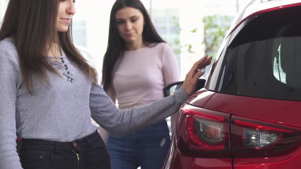 Cropped Shot of Two Women Choosing Cars at the Dealership alt
