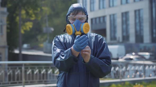 Joyful Young Man Taking Off Gloves and Respirator and Making Victory Gesture. Portrait of Happy alt