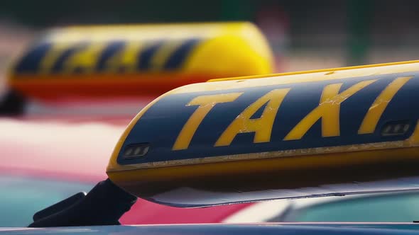 Taxi Car with Yellow Roof Sign Driving Along Street. Passenger Transport in Cities. Close Up View alt